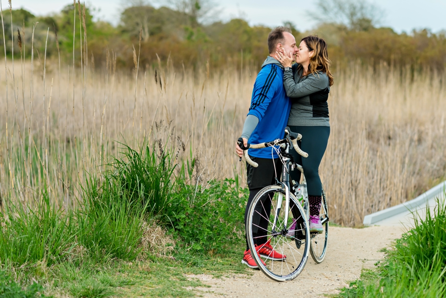 A sexy couple kiss by the beach on bikes.